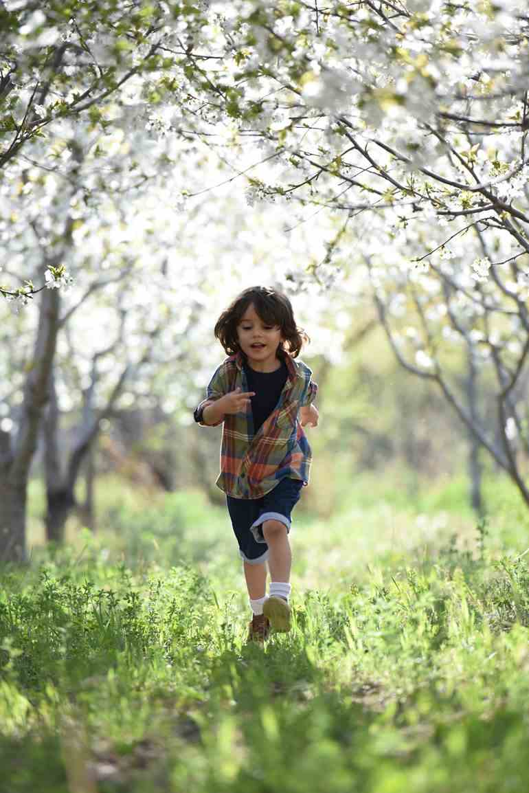 Criança correndo em grama