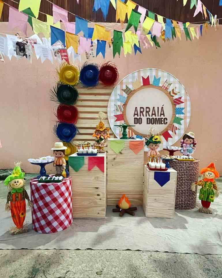 Decoração de festa junina com bandeiras e chapéus coloridos